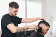 © ADDICTIVE STOCK - Young barber finishing haircut in hair salon