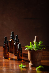 Wall Mural - fresh mint Peppermint herb leaves in mortar and essential oil in dropper bottles