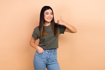 Wall Mural - Photo of young korean girl wear stylish t-shirt thumb up rate feedback like sign advertise her new job isolated on beige color background