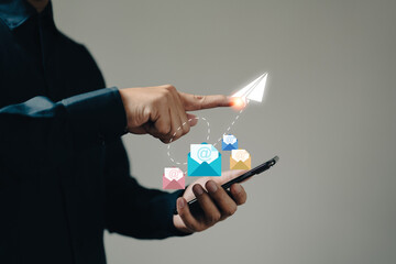 Leinwandbilder - The businessman hand holds a phone icon as it appears on the screen, representing the concept of email marketing and the use of mobile devices for promotional communication.