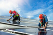 © kanpisut - Engineer working setup Solar panel at the roof top. Engineer or worker work on solar panels or solar cells on the roof of business building