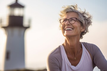 Wall Mural - Close-up portrait photography of a happy mature girl practicing yoga against a lighthouse background. With generative AI technology