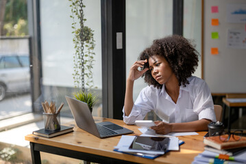 Tired business woman in stress works at a laptop while sitting at a table at office, There was a problem in the work that was done.