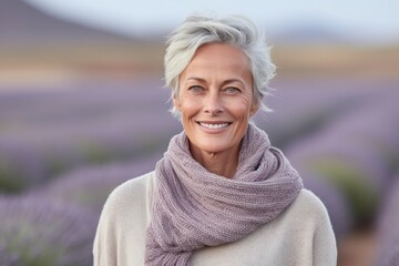 Wall Mural - Headshot portrait photography of a satisfied mature woman wearing a cozy sweater against a lavender field background. With generative AI technology