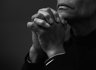 man praying to god with hands together Caribbean man praying on black background with people stock photos stock photo	