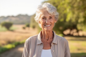 Wall Mural - Lifestyle portrait photography of a satisfied old woman wearing a casual short-sleeve shirt against a serene nature trail background. With generative AI technology