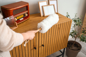 Poster - Housewife cleaning table with pp-duster at home, closeup