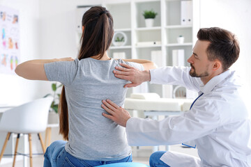 Poster - Male physiotherapist working with young woman in rehabilitation center