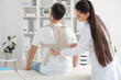 © Pixel-Shot - Young man with back brace and female physiotherapist in rehabilitation center
