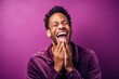 © Markus Schröder - Close-up portrait photography of a satisfied boy in his 30s placing the hand over the mouth in a laughter gesture against a vibrant purple background. With generative AI technology