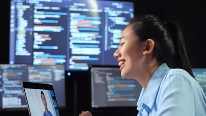 Close Up Side View Of Asian Female Programmer Having A Meeting By A Laptop While Writing Code On Multiple Monitors Showing Database On Terminal Window Desktops In The Office
