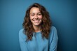 © Markus Schröder - Medium shot portrait photography of a grinning girl in her 30s crossing the arms against a cerulean blue background. With generative AI technology