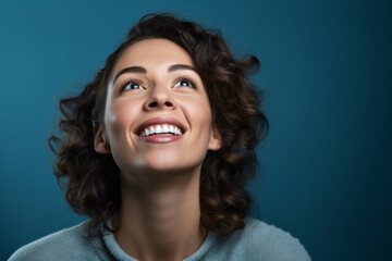 Wall Mural - Close-up portrait photography of a satisfied girl in her 30s covering one's mouth against a cerulean blue background. With generative AI technology