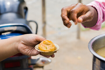 Wall Mural - Phuchka or Pani Puri being served on a bowl made of shal leaves in india. This popular street food is also called gupchup or golgappa. It is crunchy fried hollow balls made of wheat.