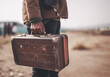 © Olena Rudo - Ai generative. Back of refugee man with suitcase in the hand