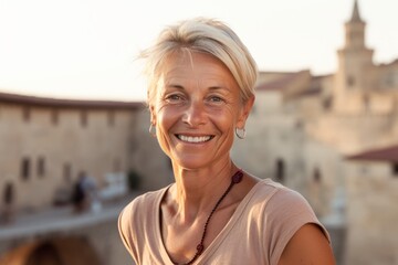 Wall Mural - Close-up portrait photography of a grinning mature woman wearing a cute crop top against a medieval castle background. With generative AI technology