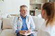 © Юлия Завалишина - Senior man doctor examining yound woman in doctor office or at home. Girl patient and doctor have consultation in hospital room. Medicine healthcare medical checkup. Visit to doctor
