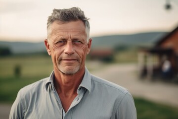 Wall Mural - Close-up portrait photography of a tender mature man wearing a classy button-up shirt against a picturesque countryside background. With generative AI technology