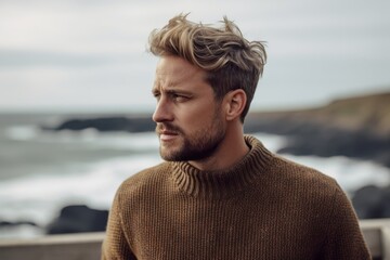 Sticker - Close-up portrait photography of a satisfied boy in his 30s wearing a cozy sweater against a scenic ocean cliff background. With generative AI technology