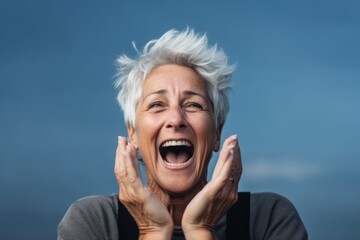 Poster - Headshot portrait photography of a joyful mature woman putting hands on the face in a gesture of terror against a sky-blue background. With generative AI technology