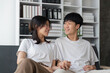 © Natee Meepian - Happy young asian couple relax on cozy sofa at home hugging look at each other, enjoy weekend at home