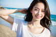 ビーチ・海辺で笑顔でカメラ目線の若い日本人女性(美人モデル)