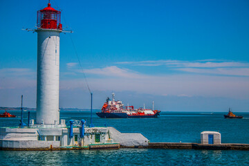 Wall Mural - Ships sail out of the port area next to the lighthouse