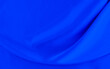 Black blue satin dark fabric texture luxurious shiny that is abstract silk cloth background with patterns soft waves blur beautiful.