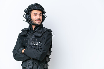 Wall Mural - Young caucasian SWAT man isolated on white background with arms crossed and happy