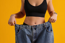 Slim Girl In Oversized Pants Shows The Result Of Losing Weight. Diet, Nutrition And Exercise