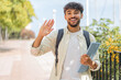 © luismolinero - Young student Arabian man at outdoors saluting with hand with happy expression