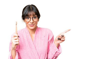 Canvas Print - Young caucasian woman holding a toothbrush over isolated chroma key background surprised and pointing finger to the side