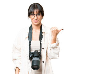 Canvas Print - Young photographer caucasian woman over isolated chroma key background pointing to the side to present a product