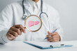 © Kiattisak - Docotr holding Magnifier focus to liver organ icon, hepatitis vaccination, liver cancer treatment. Health checkup and liver cancer concept.