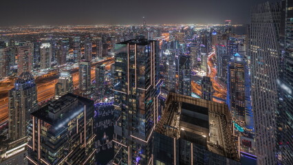 Wall Mural - Dubai Marina and JLT district with traffic on highway between skyscrapers aerial day to night timelapse.