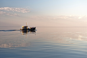 Fishing boat on sunset background