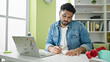 © Krakenimages.com - African american man student using laptop writing notes at library university