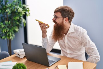 Wall Mural - Young redhead man business worker talking on smartphone working at office