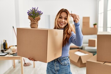 Poster - Young caucasian woman smiling confident holding package with lavender plant and key at new home