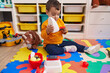 © Krakenimages.com - Adorable hispanic boy playing supermarket game sitting on floor at kindergarten