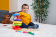 © Krakenimages.com - Adorable hispanic boy playing with hoops game sitting on bed at bedroom