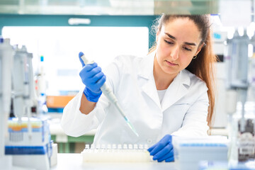 Wall Mural - Scientist with dropper dripping liquid into a test tube in scientific laboratory, concept of pharmaceutical environment