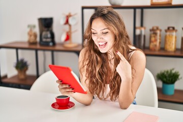 Wall Mural - Young hispanic woman doing video call with tablet smiling happy pointing with hand and finger