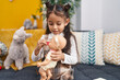 © Krakenimages.com - Adorable hispanic girl holding baby doll sitting on sofa at home