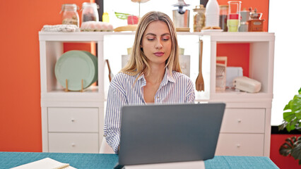 Canvas Print - Young blonde woman using laptop sitting on table at dinning room