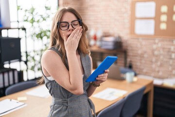 Canvas Print - Caucasian woman working at the office wearing glasses bored yawning tired covering mouth with hand. restless and sleepiness.