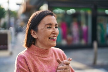 Wall Mural - Middle age woman smiling confident standing at street