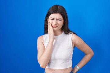 Sticker - Young caucasian woman standing over blue background touching mouth with hand with painful expression because of toothache or dental illness on teeth. dentist