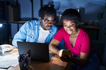 Canvas Print - African american man and woman business workers using laptop and smartphone at office