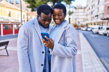 Poster - Man and woman couple standing together using smartphone at street